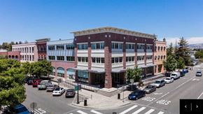 Petaluma apartment for rent - A street view of a city with a large building in the center.