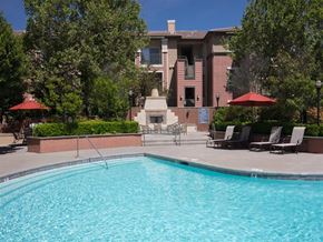 Sacramento apartment for rent - Apartments in North Natomas, Sacramento, CA, with In-Unit Washer and Dryer - Granite Point Apartments - Swimming Pool With Clear Blue Water, Poolside Lounge Chairs, and Red Umbrellas.