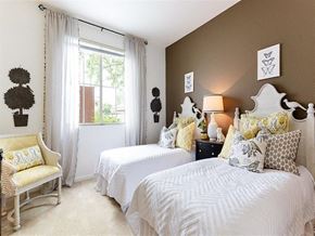 Ventura apartment for rent - Ventura, Ca, Apartments Near Grant Park -Vanoni Ranch - A Cozy Bedroom With Two Twin Beds Featuring White Carved Headboards, Yellow And Grey Patterned Pillows, And A Brown Accent Wall.