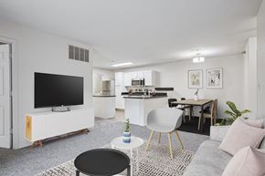Little Rock apartment for rent - 2 & 3-Bedroom Apartments for Rent in Little Rock, AR – Capitol Hill – A modern living room with a television, a dining table, and a kitchen area.