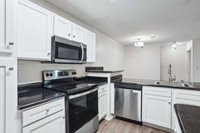 Little Rock apartment for rent - Apartments for Rent in Little Rock, AR 72223– Capitol Hill -   A kitchen with white cabinets and black countertops.