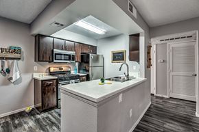 Las Vegas apartment for rent - A kitchen with a white counter top and wooden cabinets.
