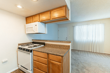 Phoenix apartment for rent - A kitchen with a white stove and wooden cabinets.