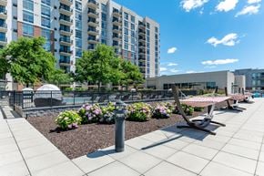Stamford apartment for rent - A modern outdoor seating area with benches and a fountain in front of apartment buildings.