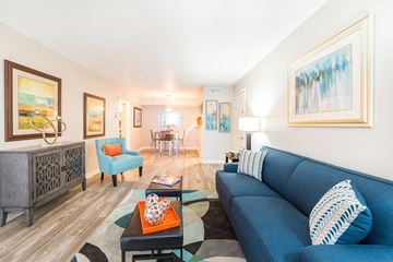 San Antonio apartment for rent - A living room with a blue couch and a wooden cabinet.