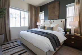Prescott apartment for rent - A bedroom with a large bed and a plant on the side table.