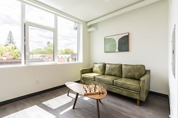 Portland apartment for rent - A living room with a green couch and a chess set on the table.