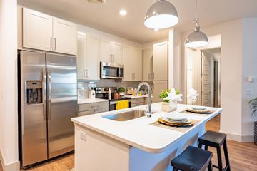 Midland apartment for rent - A modern kitchen with a stainless steel refrigerator and a white island.