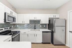 Raymore apartment for rent - A kitchen with white cabinets and appliances.
