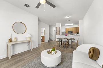 Kissimmee apartment for rent - A modern living room with a white couch and a round mirror on the wall.