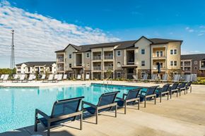 Travelers Rest apartment for rent - the standard at pinestone travelers rest sc apartment community property photo of outdoor pool with lounge chairs and sparkling pool with garden style apartment building in background