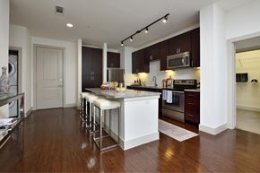College Station apartment for rent - A kitchen with white cabinets and a wooden floor.