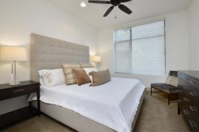 College Station apartment for rent - A bedroom with a large bed and a ceiling fan.