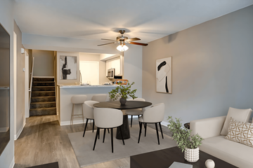 Hermantown apartment for rent - A living room with a white couch, a round table with chairs, and a ceiling fan.