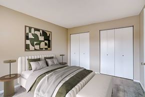 Hermantown apartment for rent - A bedroom with a large bed and a painting on the wall.