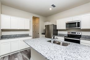 Deland townhouse for rent - A kitchen with granite countertops and stainless steel appliances.
