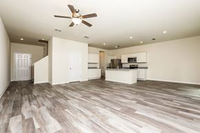 Deland townhouse for rent - A spacious room with a ceiling fan and lighting fixtures.