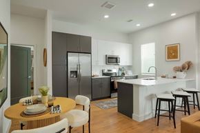 Denver apartment for rent - Colorado Apartments Near Denver Botanical Gardens - Edera Apartments - Kitchen With Grey and White Cabinetry, White Countertops, White Tile Backsplash, Luxury LVT Flooring, and Stainless Steel Appliances