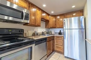 Los Gatos apartment for rent - Dog-Friendly Apartments in Los Gatos, CA - El Gato Penthouse - Compact Kitchen With Stainless Steel Appliances, Warm Wood Cabinetry, Granite Countertops, And Tile Flooring.