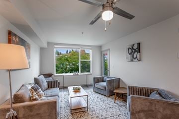 Seattle apartment for rent - a living room with couches and chairs and a ceiling fan