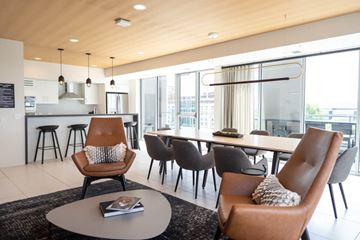 Bloomington apartment for rent - A modern living room with a brown leather chair and a grey coffee table.