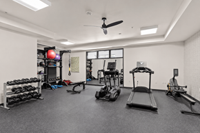 Sherwood apartment for rent - A spacious gym with a variety of equipment including a treadmill, weights, and a bench press.