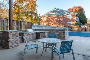 Kansas City apartment for rent - a patio with a table and chairs in front of a pool