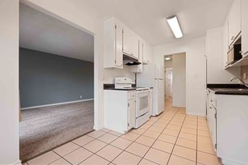 Fremont apartment for rent - a kitchen with white cabinets and appliances and a laundry room