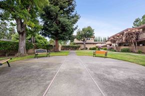 Fremont apartment for rent - a park with benches and trees in front of a building