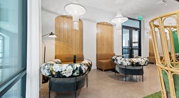 Scottsdale apartment for rent - A modern living room with a floral patterned sofa and a wooden chair.