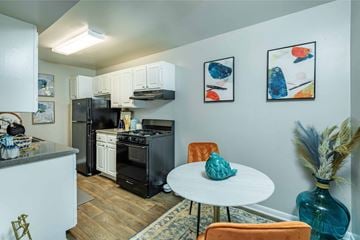 Raleigh apartment for rent - A kitchen with a black fridge and a white table.