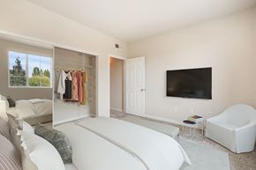 Sacramento apartment for rent - a bedroom with a white bed and a tv on the wall