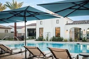 Apache Junction apartment for rent - A pool with a blue umbrella and chairs.
