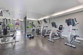 Santa Clara apartment for rent - Pet-Friendly Apartments in Santa Clara, CA - Hidden Lake - Fitness Center with Cardio Machines, A Large Mirrored Wall, Dumbbells, and Weight Lifting Machine.