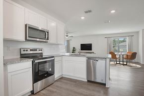 Palm Bay townhouse for rent - A modern kitchen with white cabinets and stainless steel appliances.