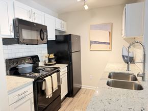 Greensboro apartment for rent - A kitchen with black appliances and white cabinets.