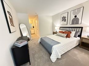Greensboro apartment for rent - A bedroom with a large bed and a mirror on the wall.