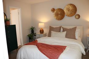Greensboro apartment for rent - A bedroom with a large bed and a red blanket.