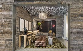 Oakland apartment for rent - A modern living room with a stone wall and a patterned ceiling.