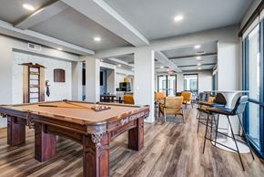 Phoenix apartment for rent - Luxury Apartments Downtown Phoenix, AZ - Imperial Apartments - Clubhouse with Pool Table, Mounted TV, Wood-Style Flooring, Tables, Chairs, and High Ceilings.