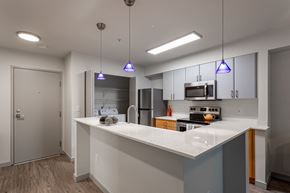 Seattle apartment for rent - Apartments for Rent in Fremont, WA - Epicenter - Kitchen with Island, Modern Light Fixtures, Wood-Style Flooring, Granite Counters, and Stainless-Steel Appliances