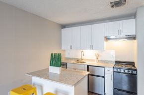 San Antonio apartment for rent - A kitchen with white cabinets and a granite countertop.