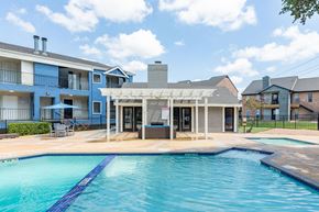 San Antonio apartment for rent - A swimming pool in front of a building with a covered patio area.