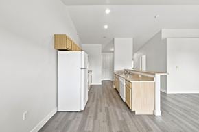 Spokane apartment for rent - A kitchen with a white refrigerator and wooden cabinets.