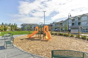 Olympia apartment for rent - A playground with a slide and a bench in the foreground.