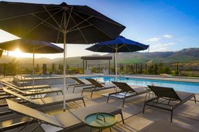 Verdi apartment for rent - A sunny day at the pool with lounge chairs and umbrellas.