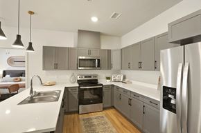 Verdi apartment for rent - A modern kitchen with a stainless steel refrigerator and a white countertop.