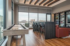 Kenosha apartment for rent - A pool table is in the middle of a room with a bar and a view of the city.