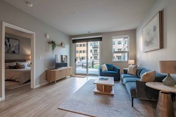 Kenosha apartment for rent - A living room with a grey couch and a wooden coffee table.