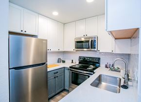 Las Vegas apartment for rent - Las Vegas, NV, Apartments Near Joe's Bar - Haven at Lone Mountain - A Kitchen With White Shaker Cabinets, Stainless Steel Refrigerator And Microwave, Electric Range, And White Countertops.